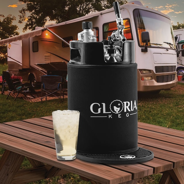 Big G 10L Gloria Keg on a picnic table with an iced beverage in front of an RV in a campground.