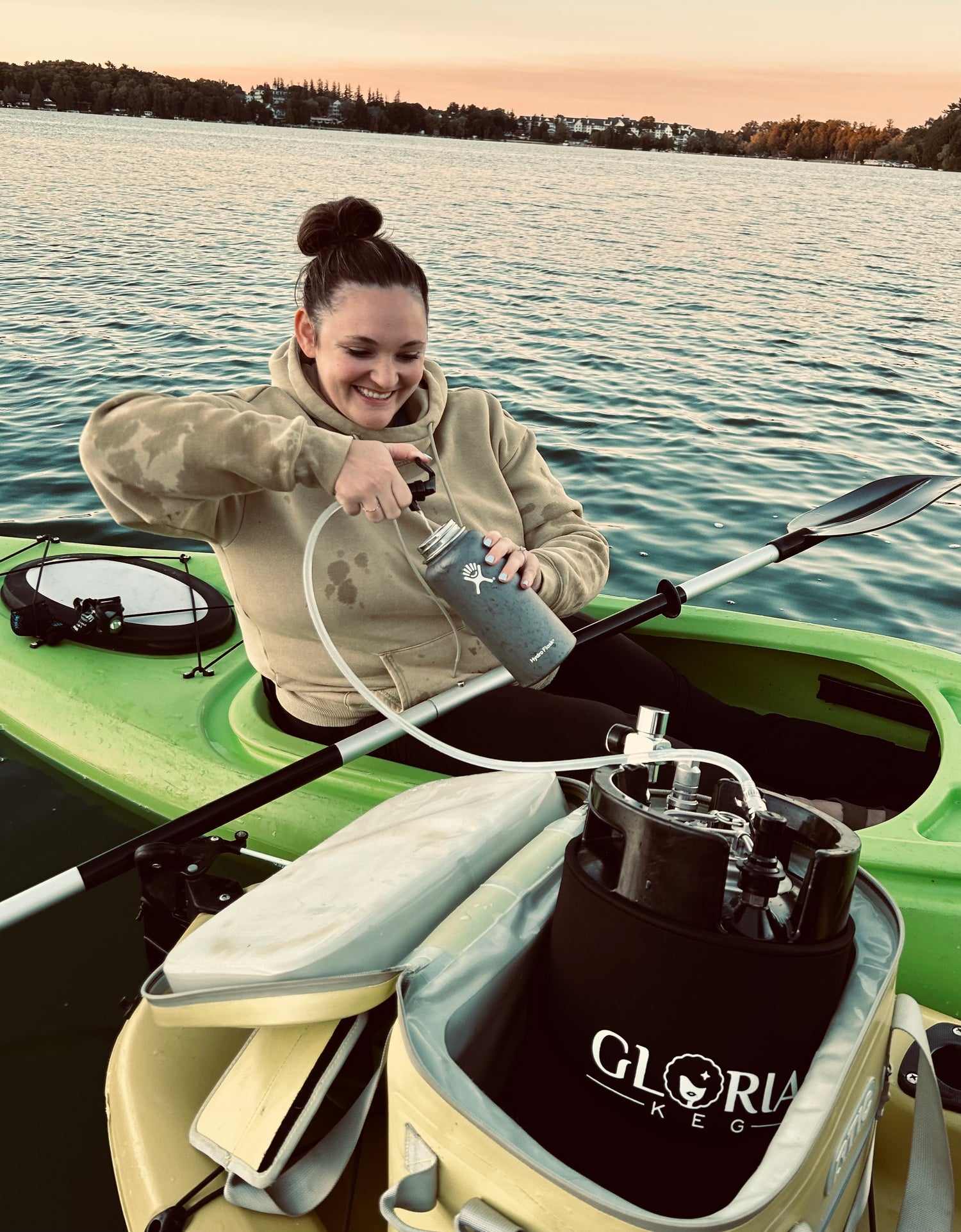 Black 7L Gloria Keg being used on a kayak on a lake with picnic tap assembly