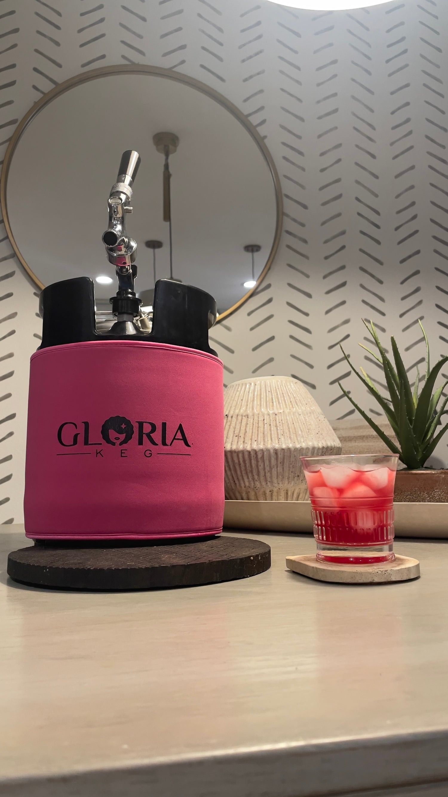 Pink 7L Gloria Rose on a table with a pink cocktail